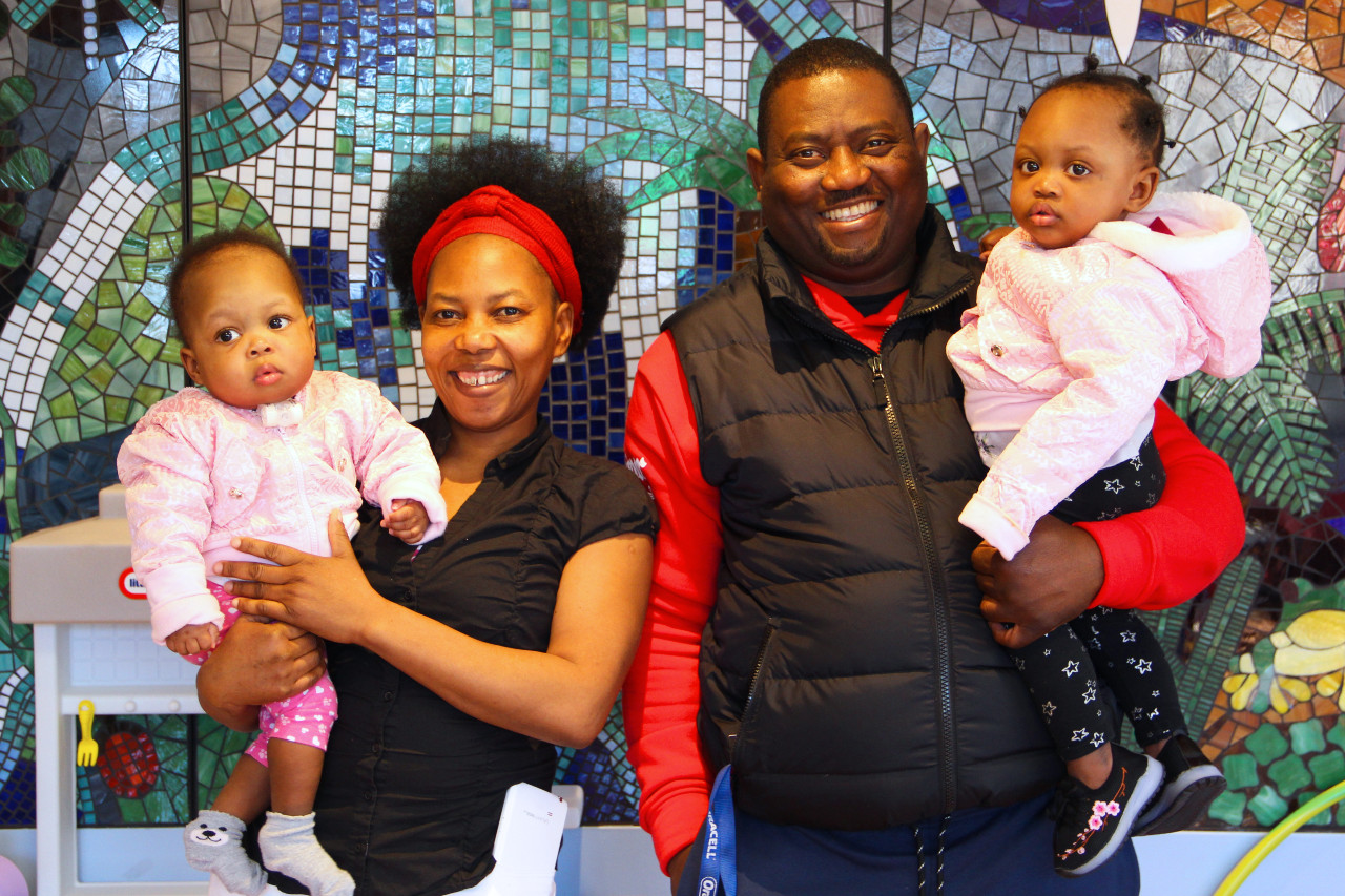 a mother and father holding their twin daughters
