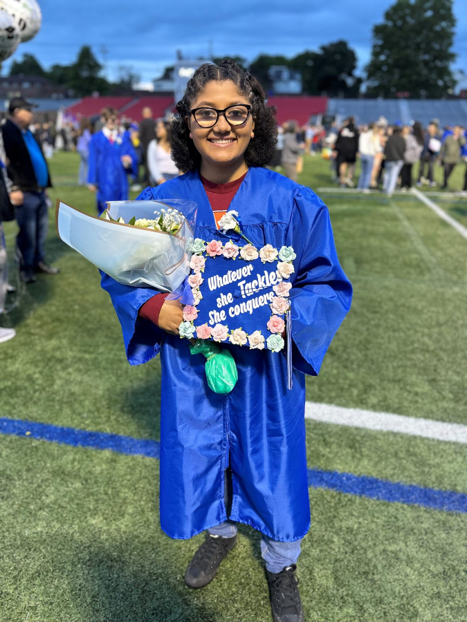 a girl wearing a graduation gown and showing off her cap