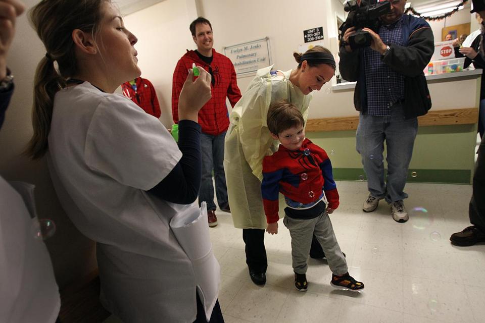 a boy walking down a hall with people around him