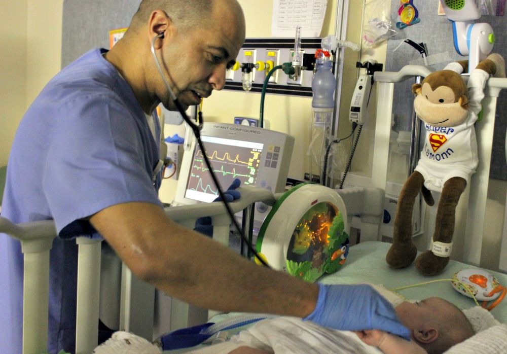 a medical provider listening to a babys heart