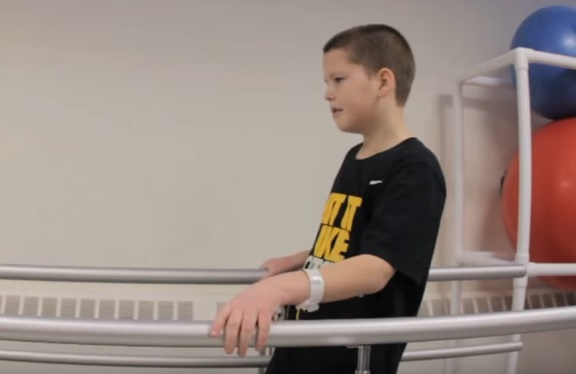 a boy walking with railing on both sides
