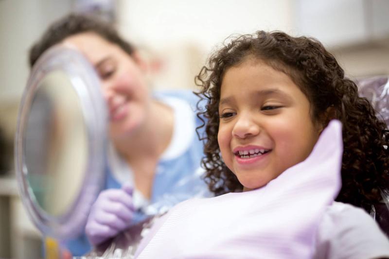 a girl in a dental chair smiling