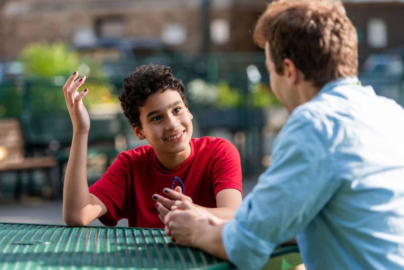 a young teenage boy talking to a counselor
