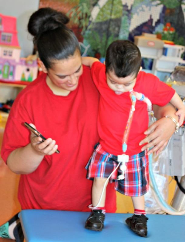 a mom helping her son start to walk